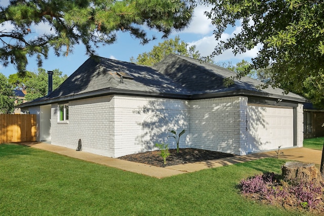 view of side of home with a lawn and a garage