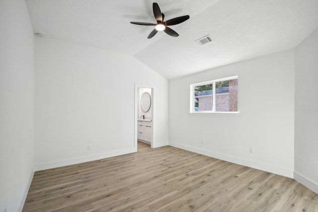 unfurnished room with ceiling fan, a textured ceiling, lofted ceiling, and light hardwood / wood-style flooring