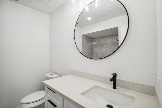 bathroom with toilet, a textured ceiling, and vanity