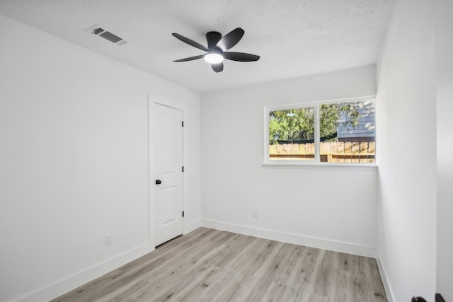 empty room with light hardwood / wood-style floors, a textured ceiling, and ceiling fan