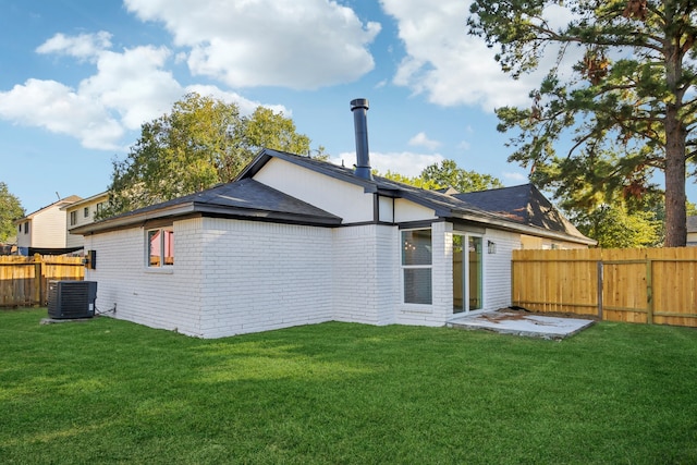 rear view of house featuring central air condition unit, a patio, and a lawn