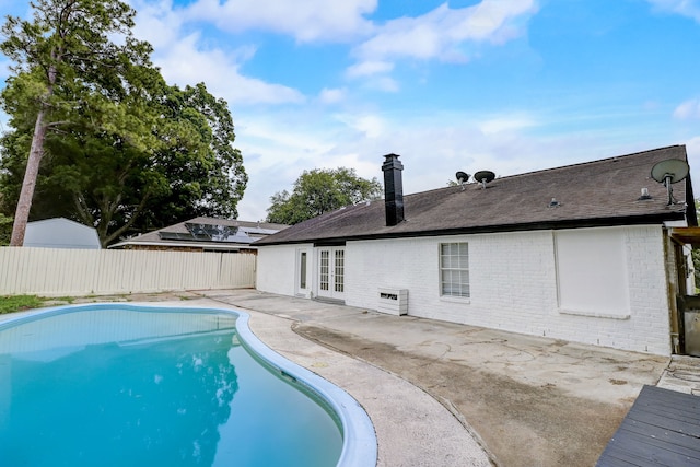 view of swimming pool with a patio and french doors