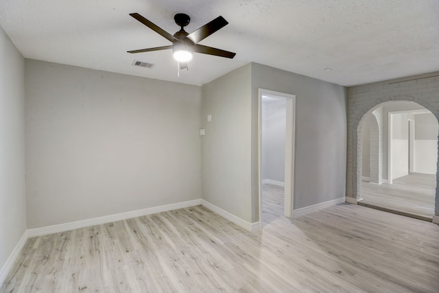 empty room with light hardwood / wood-style floors, a textured ceiling, and ceiling fan