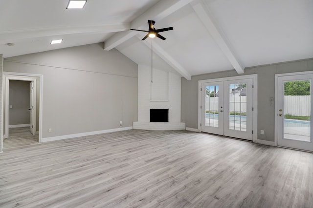 unfurnished living room featuring french doors, vaulted ceiling with beams, light wood-type flooring, a fireplace, and ceiling fan