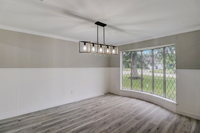 unfurnished room featuring crown molding, a notable chandelier, and light wood-type flooring