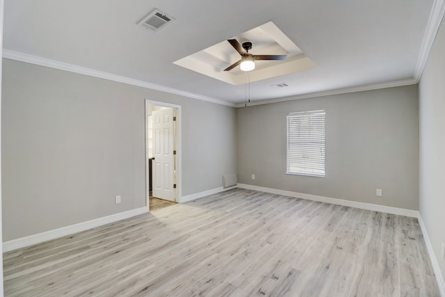 spare room with light hardwood / wood-style floors, crown molding, a raised ceiling, and ceiling fan