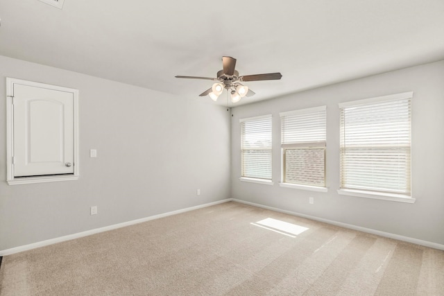 carpeted spare room featuring ceiling fan