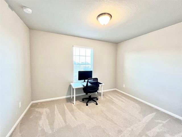 carpeted home office featuring a textured ceiling