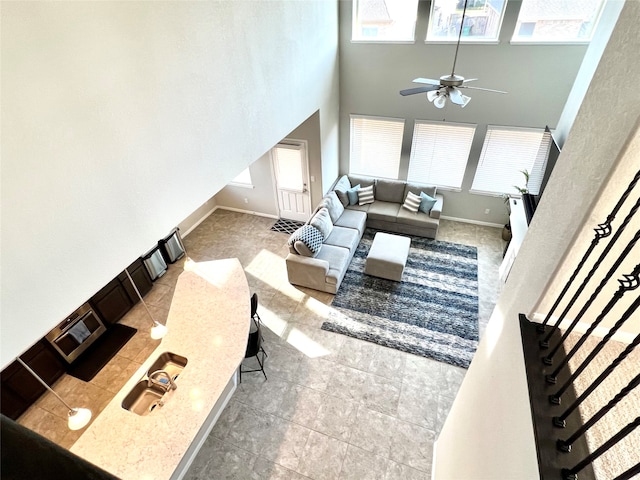 living room with a towering ceiling and ceiling fan