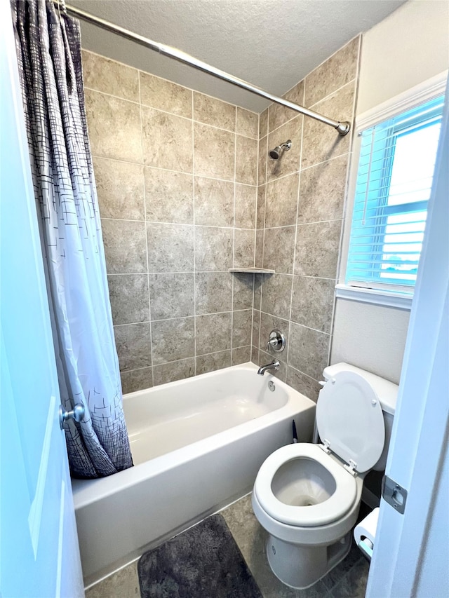 bathroom with toilet, a textured ceiling, and shower / tub combo with curtain