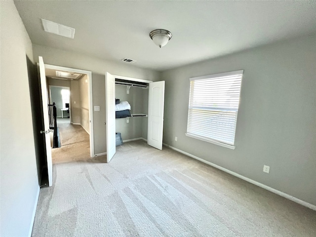 unfurnished bedroom featuring light carpet and a closet