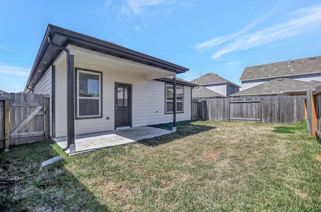 rear view of house with a patio and a yard