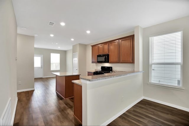 kitchen with light stone countertops, black appliances, a kitchen island, kitchen peninsula, and dark wood-type flooring