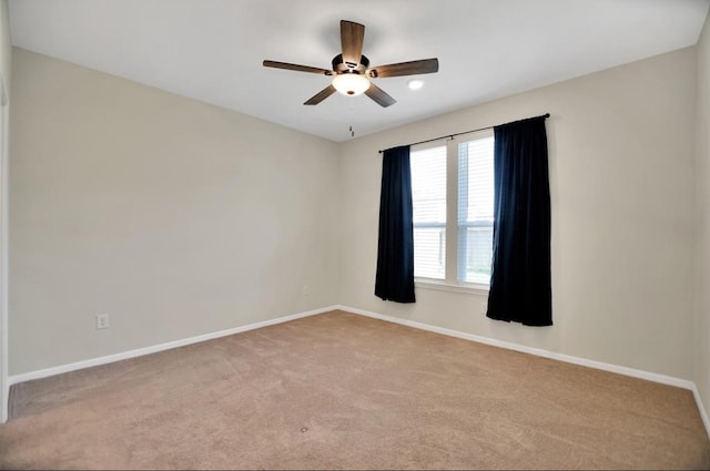 spare room featuring light carpet and ceiling fan