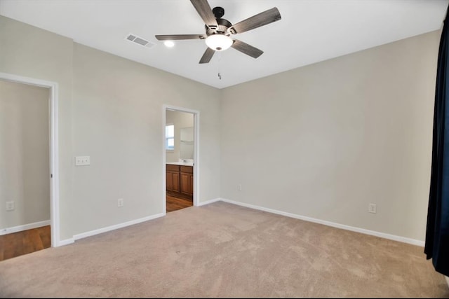 unfurnished bedroom featuring connected bathroom, ceiling fan, and light colored carpet