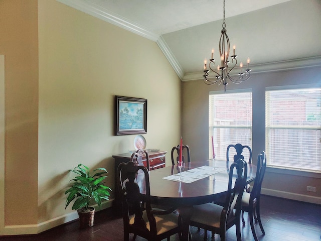 dining area with lofted ceiling, dark wood-type flooring, a notable chandelier, and ornamental molding