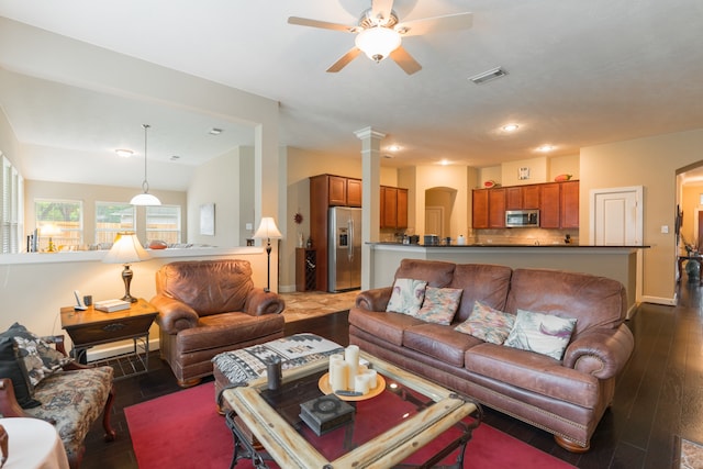 living room with dark wood-type flooring, vaulted ceiling, decorative columns, and ceiling fan