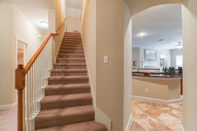 stairs with sink and ceiling fan