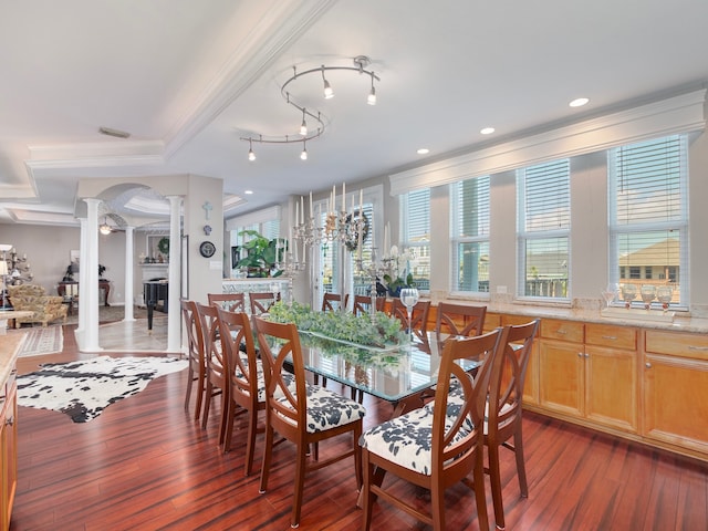 dining space with crown molding, dark wood-type flooring, and decorative columns