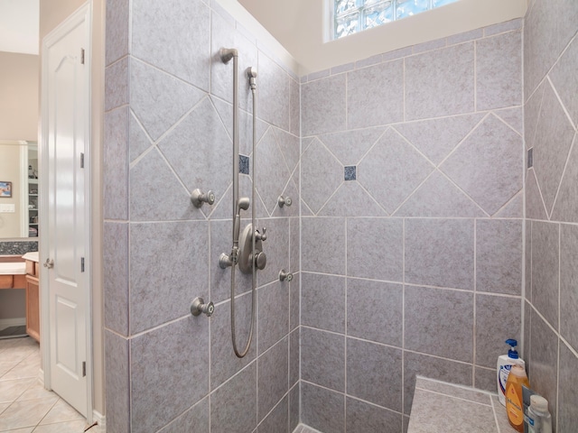 bathroom with a tile shower and tile patterned flooring