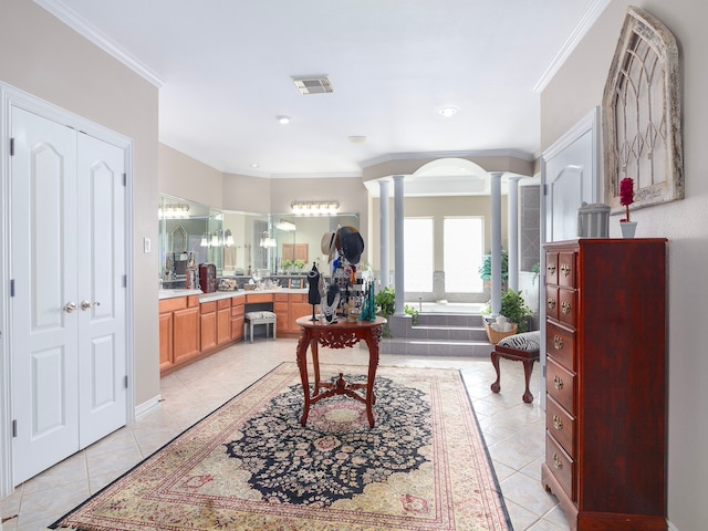 interior space featuring light tile patterned flooring, decorative columns, and ornamental molding