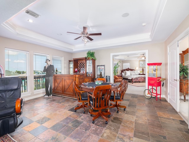 dining room with ceiling fan and a raised ceiling