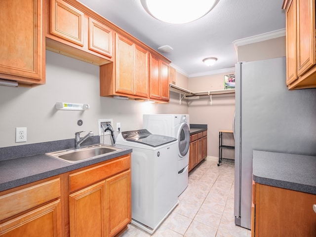 laundry room with independent washer and dryer, sink, crown molding, light tile patterned floors, and cabinets