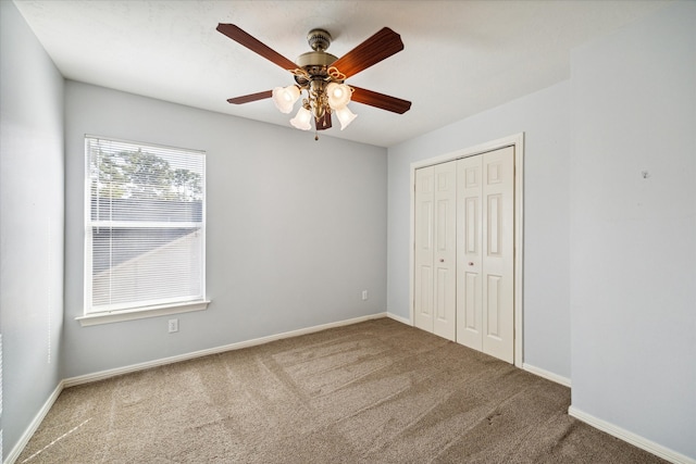 unfurnished bedroom with ceiling fan, a closet, and carpet floors