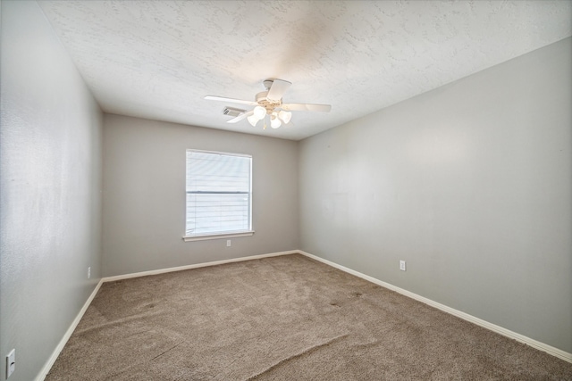 empty room with carpet floors, ceiling fan, and a textured ceiling