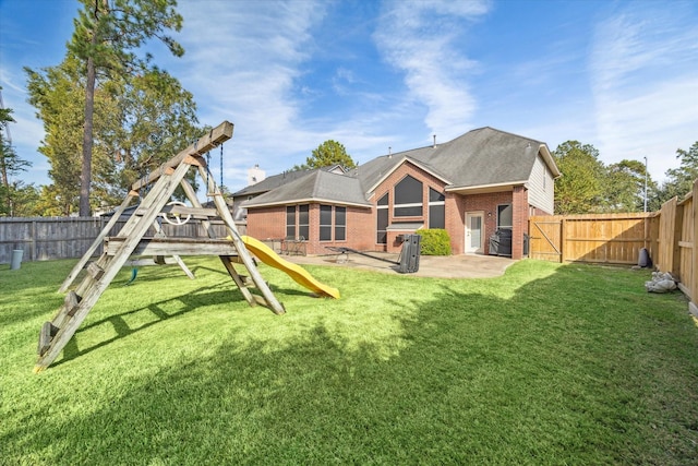 back of house featuring brick siding, a fenced backyard, a patio, and a playground