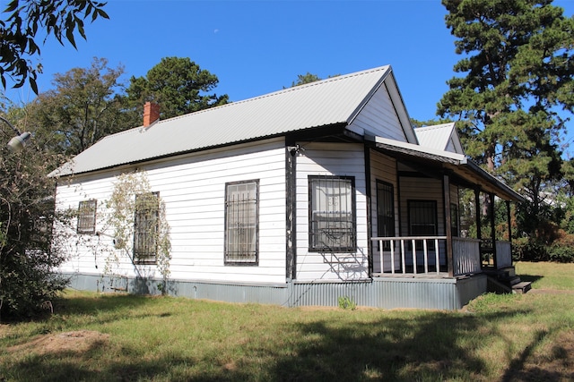 view of home's exterior featuring covered porch and a yard