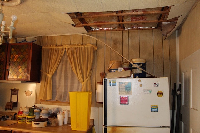 interior space with wooden walls, sink, and white refrigerator