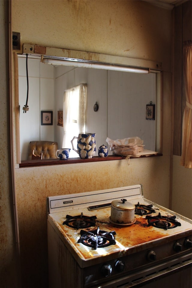 kitchen featuring white gas range and dark brown cabinets