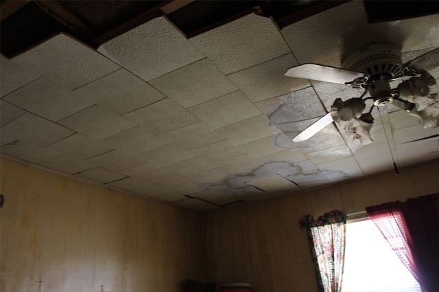 room details featuring wooden walls and ceiling fan