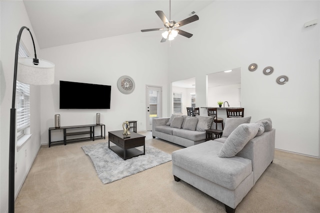 carpeted living room featuring ceiling fan and high vaulted ceiling