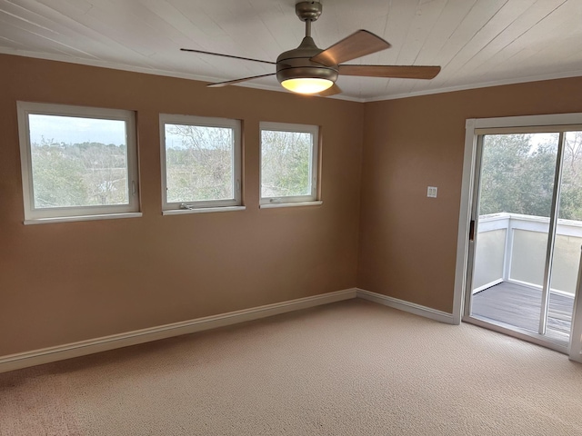 unfurnished room featuring a ceiling fan, light colored carpet, crown molding, and baseboards