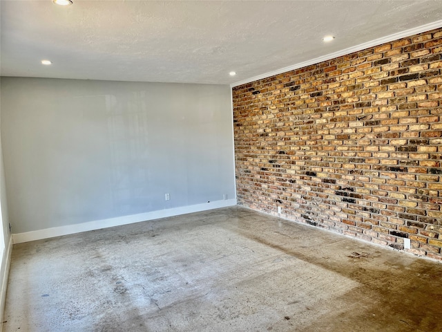 unfurnished room featuring crown molding, a textured ceiling, and brick wall