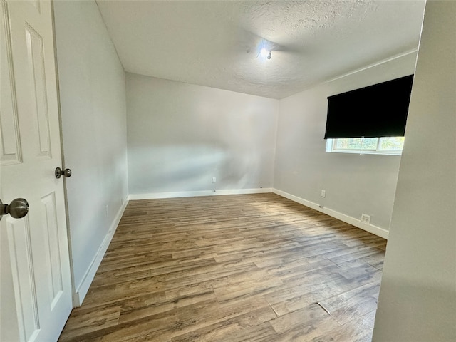 spare room with hardwood / wood-style floors and a textured ceiling