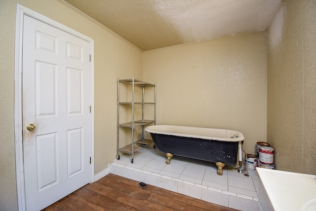 interior space featuring crown molding, hardwood / wood-style flooring, and a textured ceiling