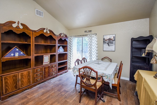 dining area featuring lofted ceiling and hardwood / wood-style flooring