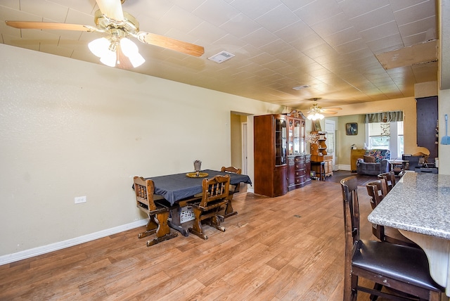 dining room with light wood-type flooring and ceiling fan