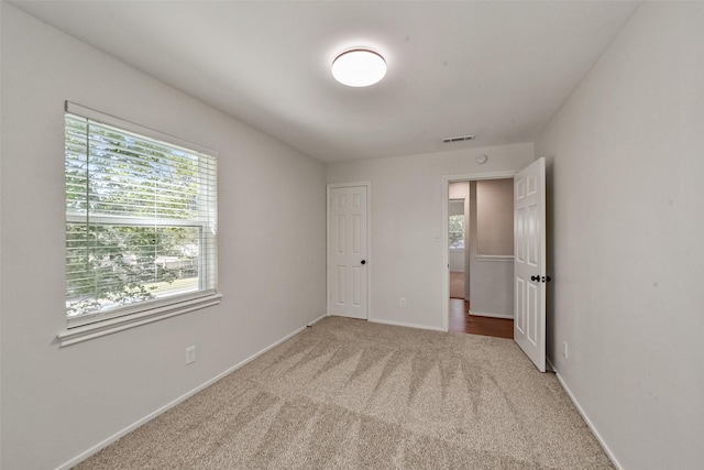 unfurnished bedroom featuring baseboards, visible vents, and carpet flooring