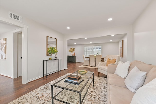 living area with baseboards, wood finished floors, visible vents, and recessed lighting