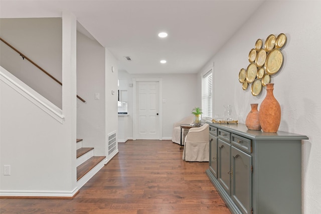 hallway with stairs, visible vents, dark wood finished floors, and recessed lighting