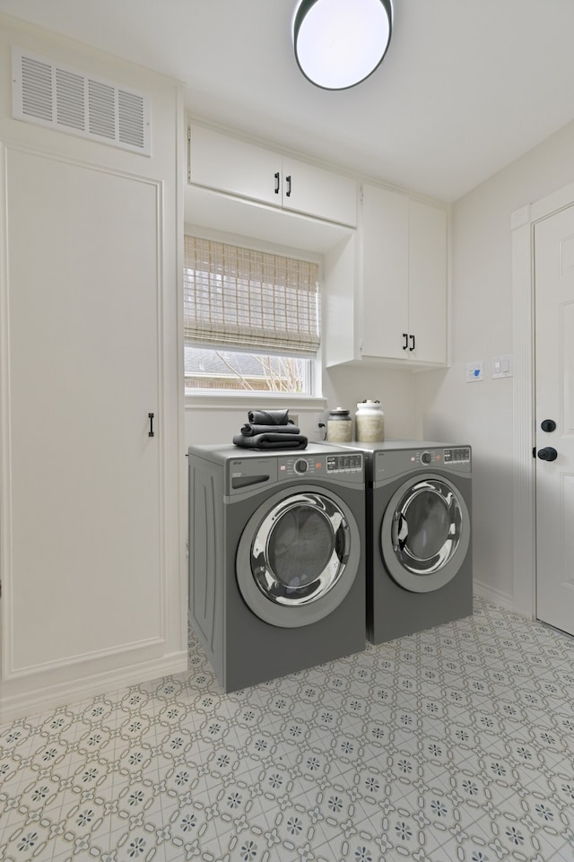 laundry area with cabinet space, visible vents, and separate washer and dryer