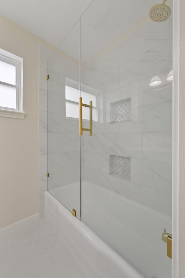 full bath featuring shower / bath combination with glass door, baseboards, and tile patterned floors