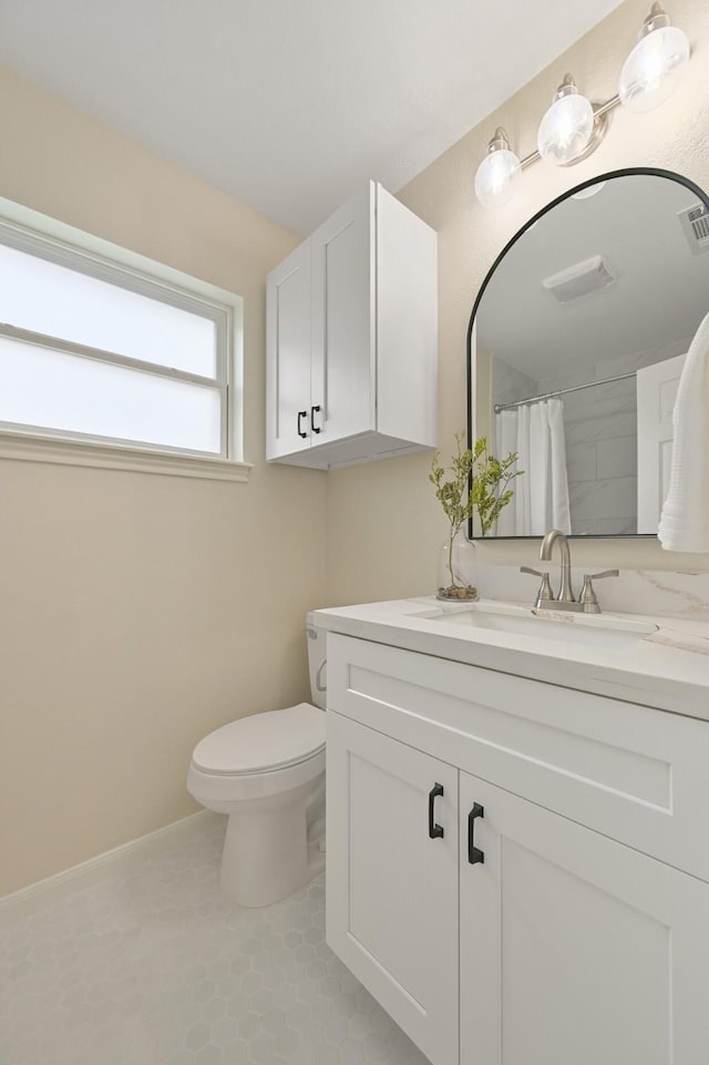 bathroom with curtained shower, vanity, toilet, and tile patterned floors