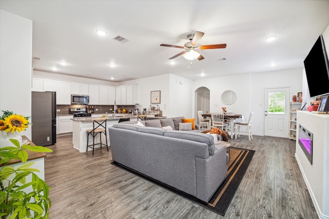 living room with light hardwood / wood-style flooring and ceiling fan