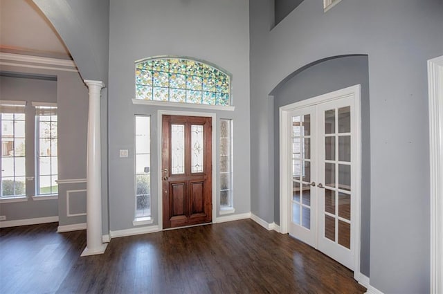 entrance foyer with a healthy amount of sunlight, dark wood-type flooring, and decorative columns