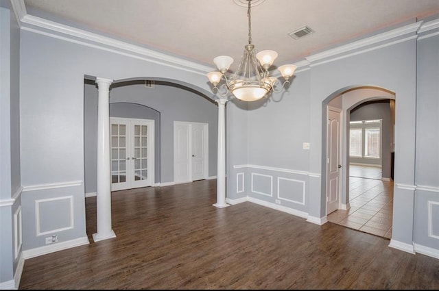 unfurnished dining area with french doors, crown molding, dark hardwood / wood-style floors, and decorative columns